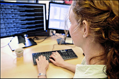 woman working at computer with code on screen