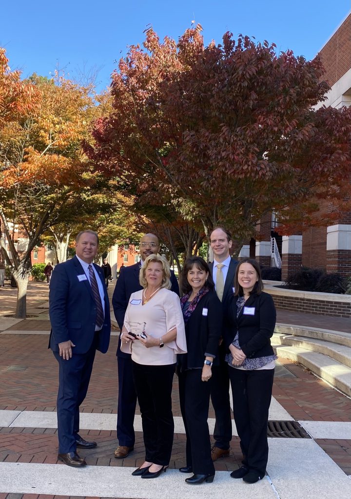 Group picture of people standing near a tree with their SAN award.