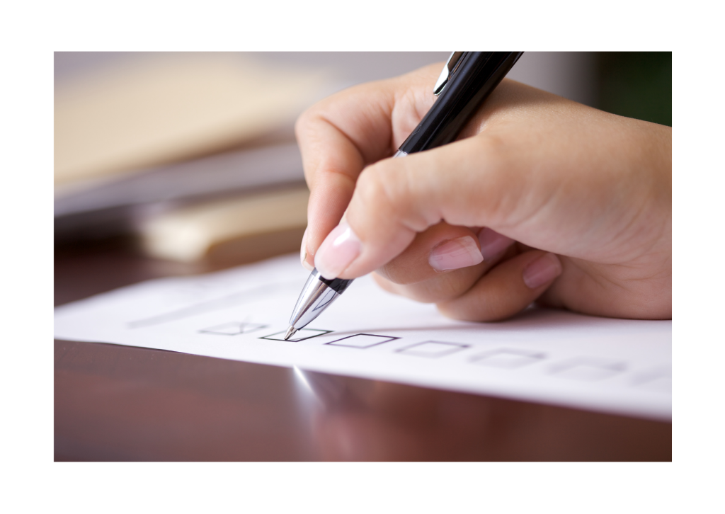 A hand holding a pen marking off checklist boxes.
