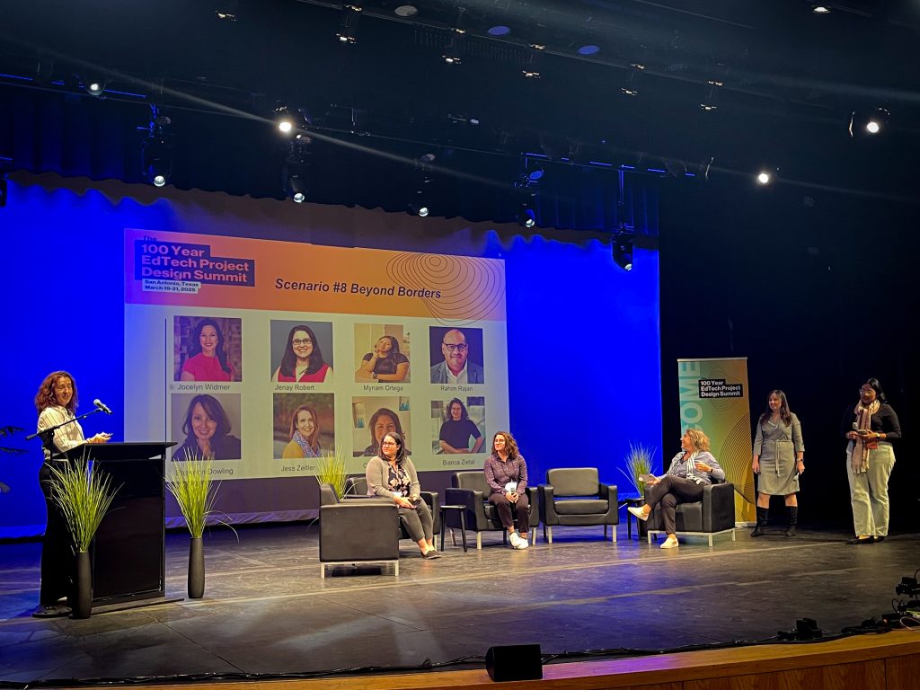 Six individuals on a stage with a projector screen behind them that reads "100 year EdTech project design summit" and "scenario 8 Beyond Borders."