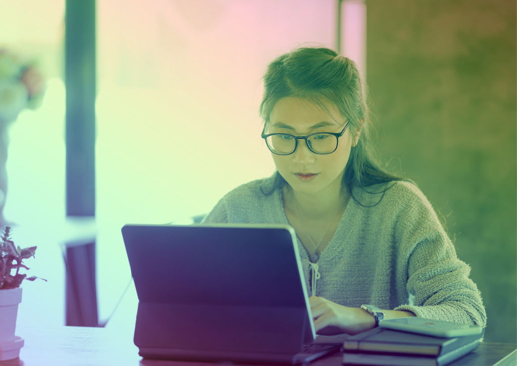 A young woman sitting at a laptop working.