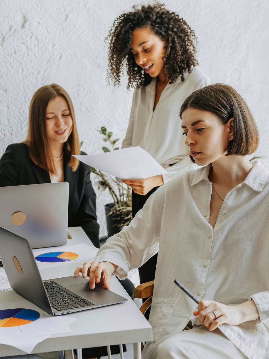 three professional women working on laptops