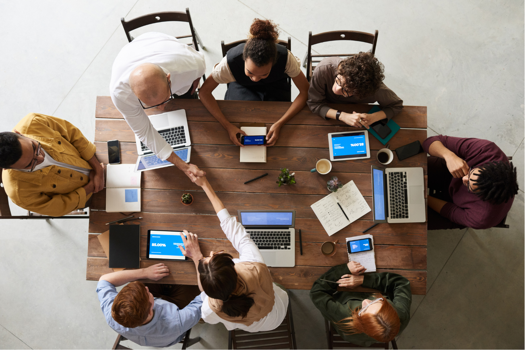 Large group of individuals around a table, view from above them - showing how professionals may work together to build buy-in