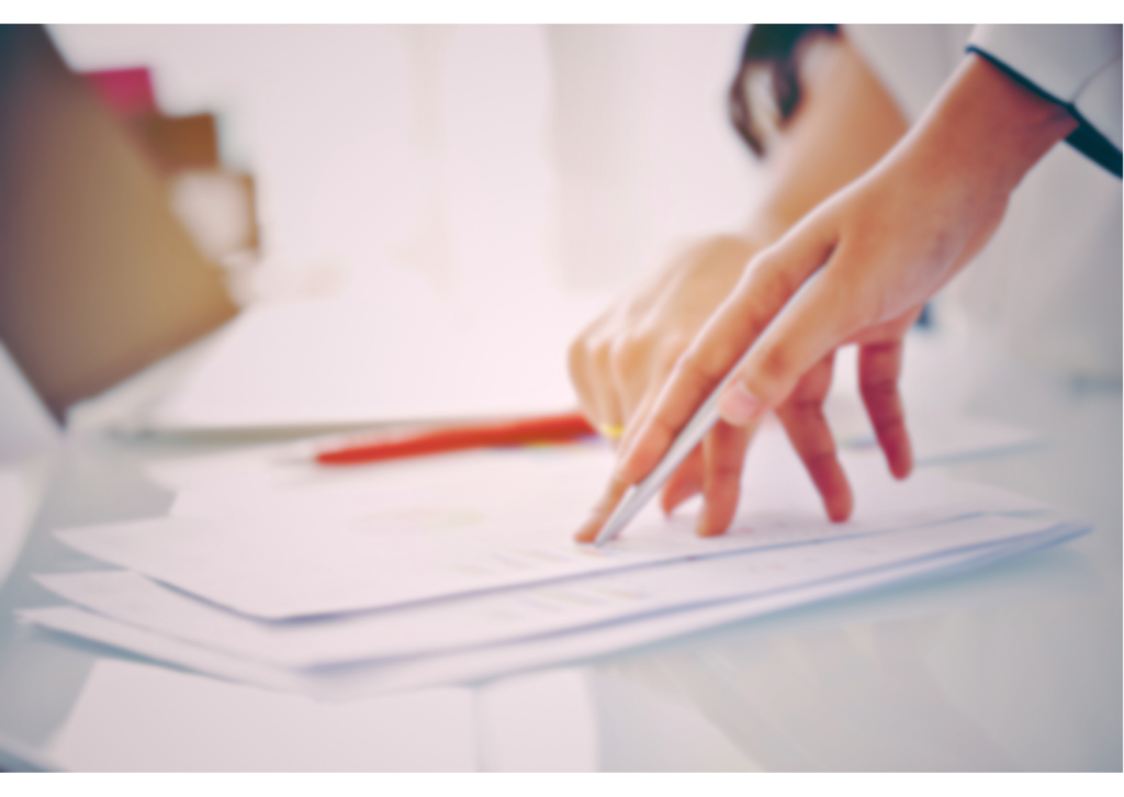 Image of a hand signing paperwork