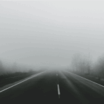 A road leading to a large fog bank